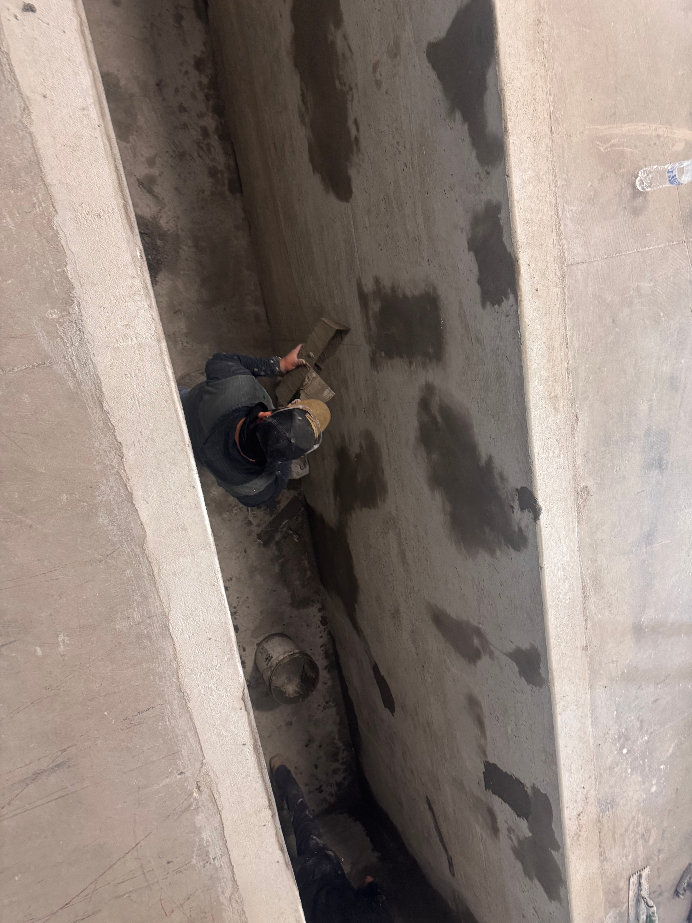 Worker finishing concrete in the pit trench