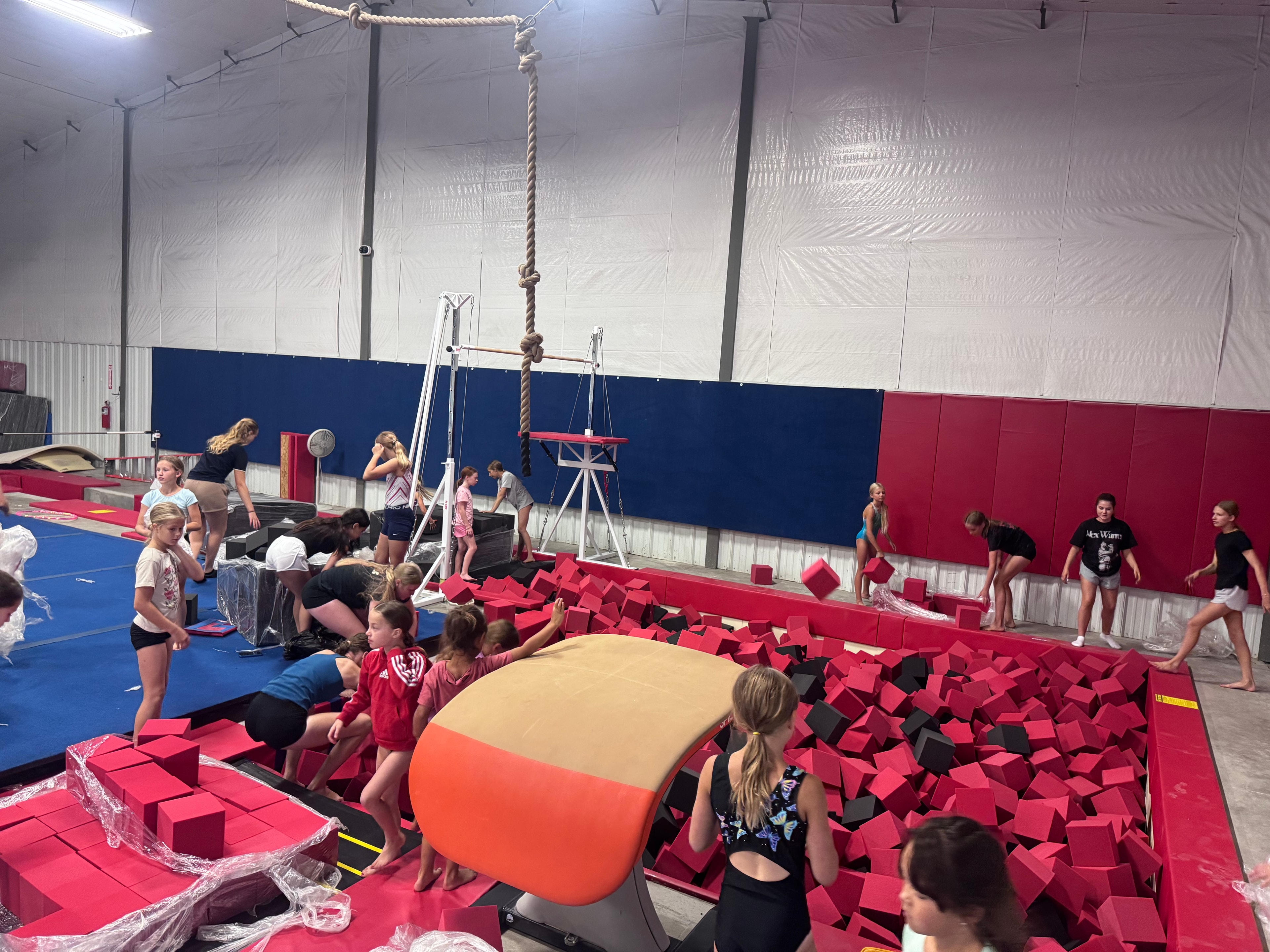 Gymnasts filling the foam pit with foam blocks