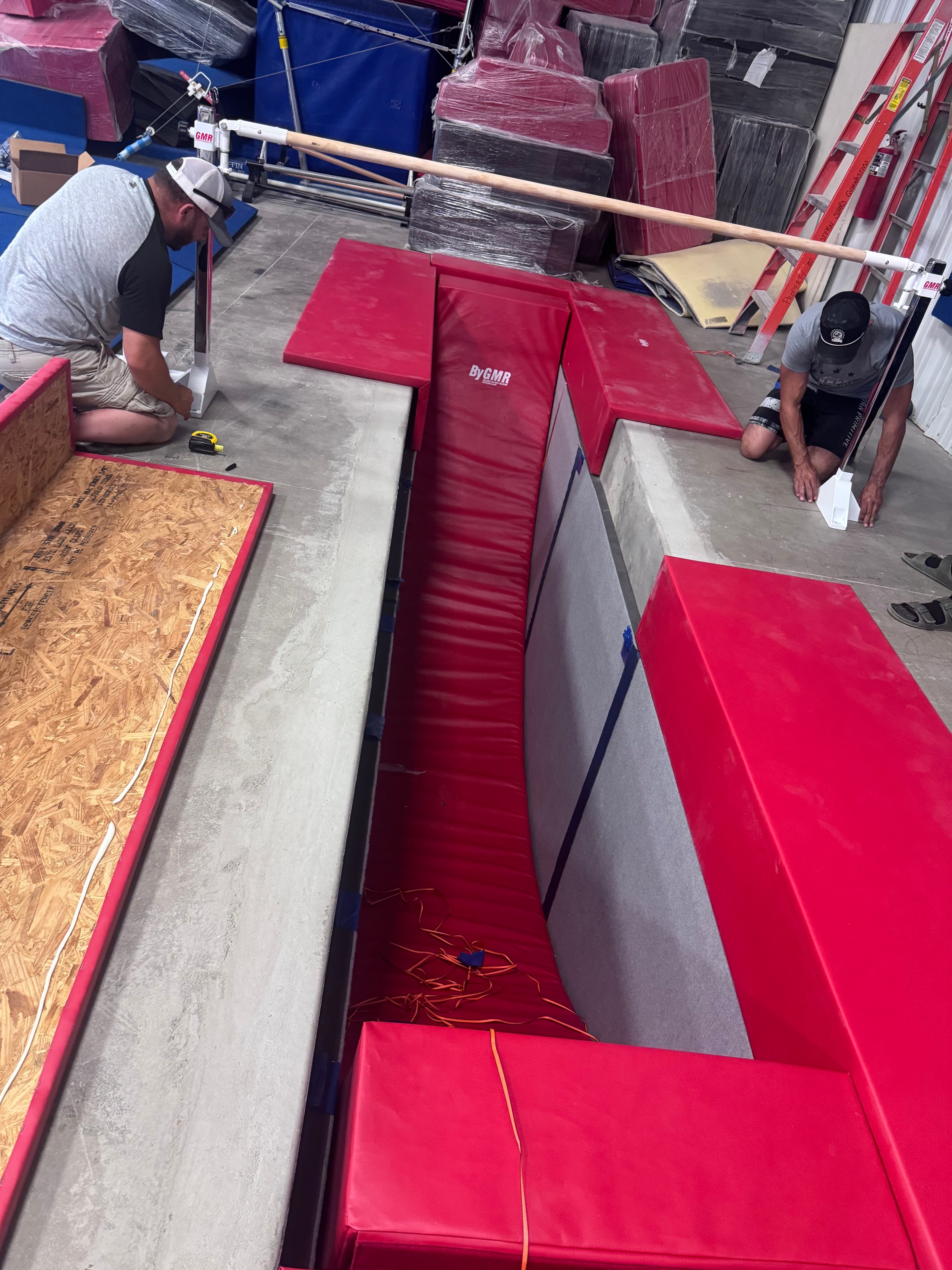 Team installing foam pit padding and mats